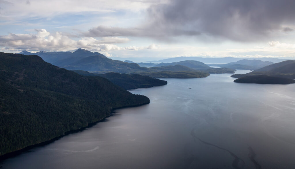 Aerial Landscape view with broken rain clouds covering the sky. Picture taken at Jervis Inlet North of Sunshine Coast, British Columbia, Canada.