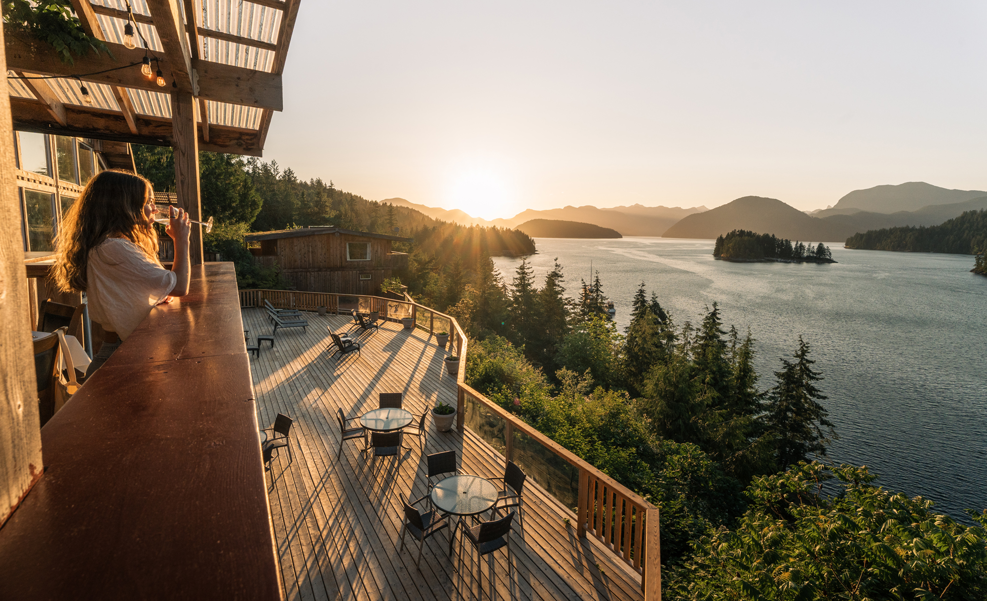 Beautiful sunset gilds the Heritage Lodge, coastal mountains, and inlet.